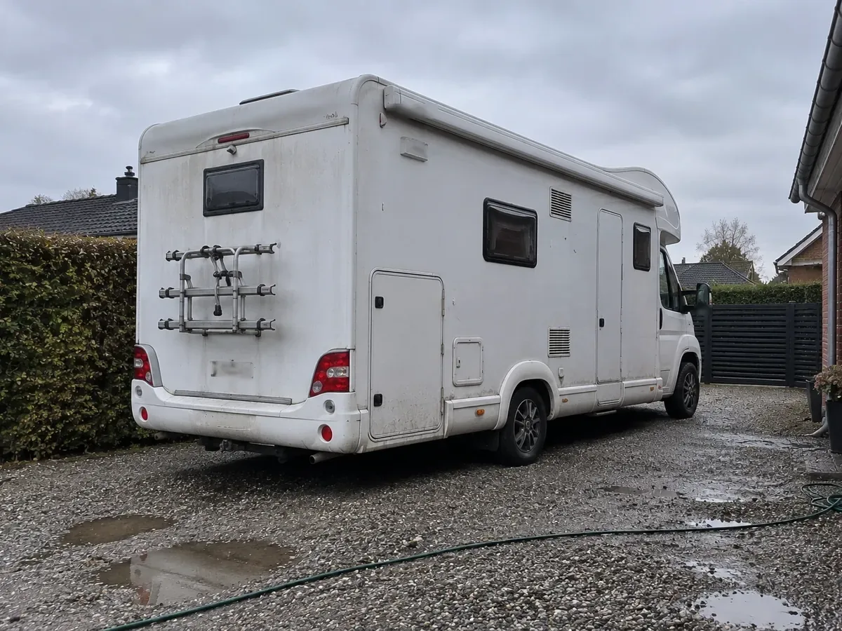 Autocamper parkeret i en indkørsel